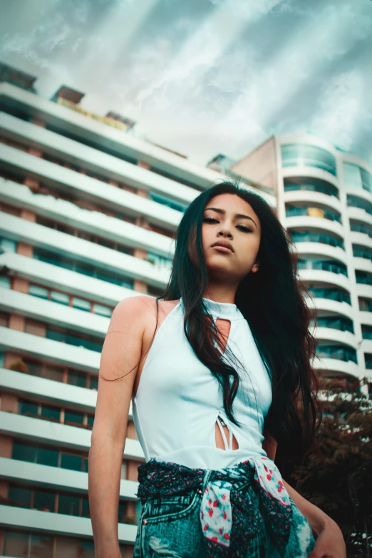 young women is posing near an apartment building