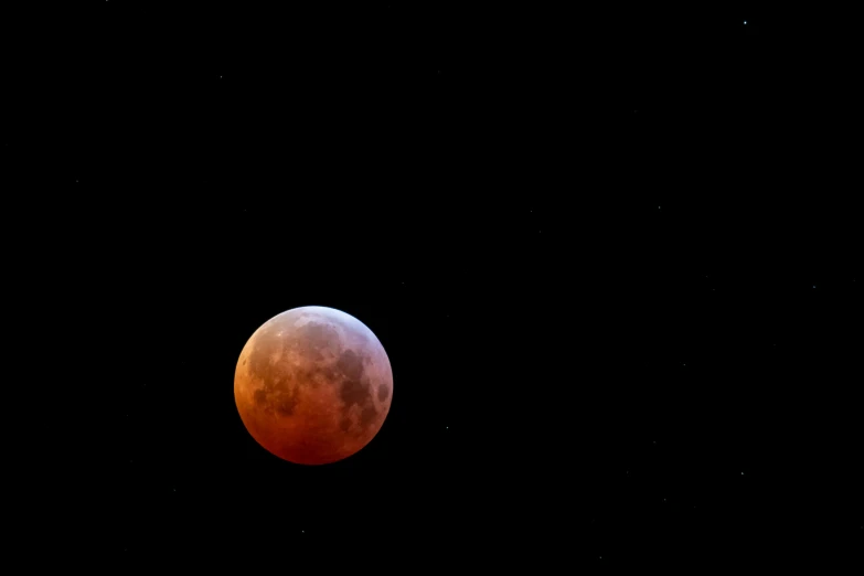 a bright red moon is shown in the sky