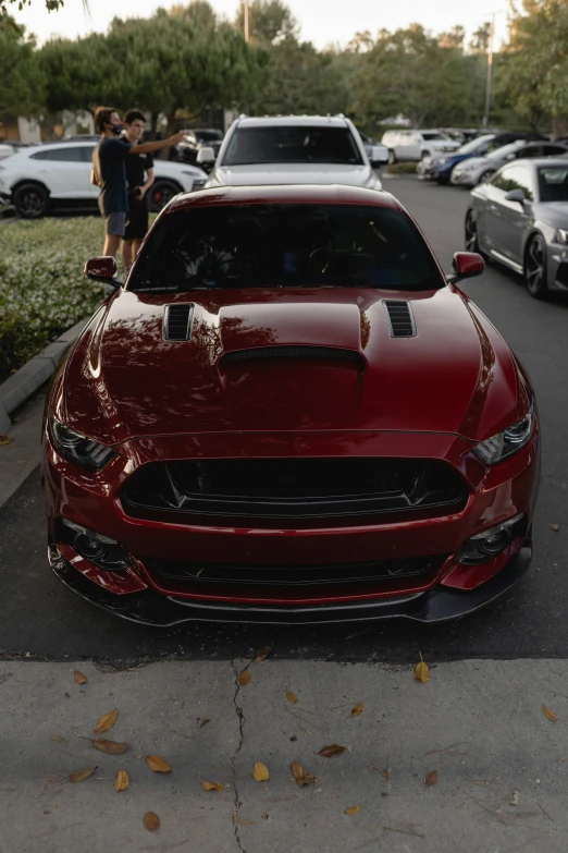 a large red mustang sitting on the side of a road