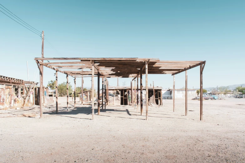 an old, rustic, wooden shelter in the desert