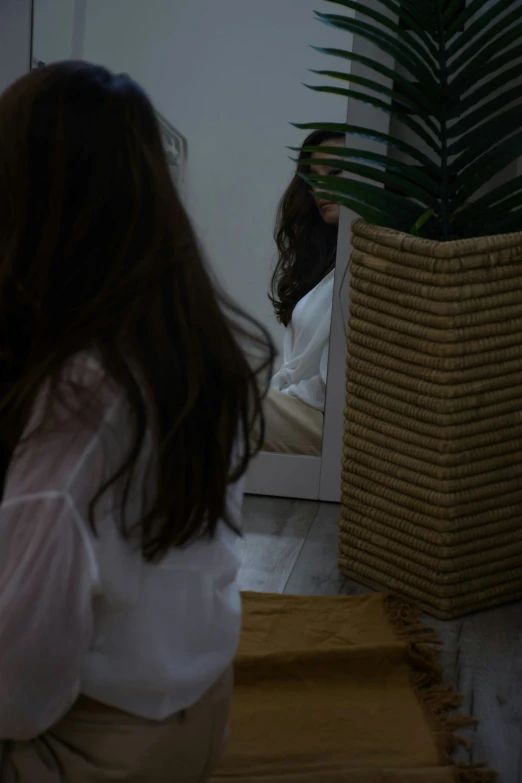 a woman sitting in a chair looking into the mirror