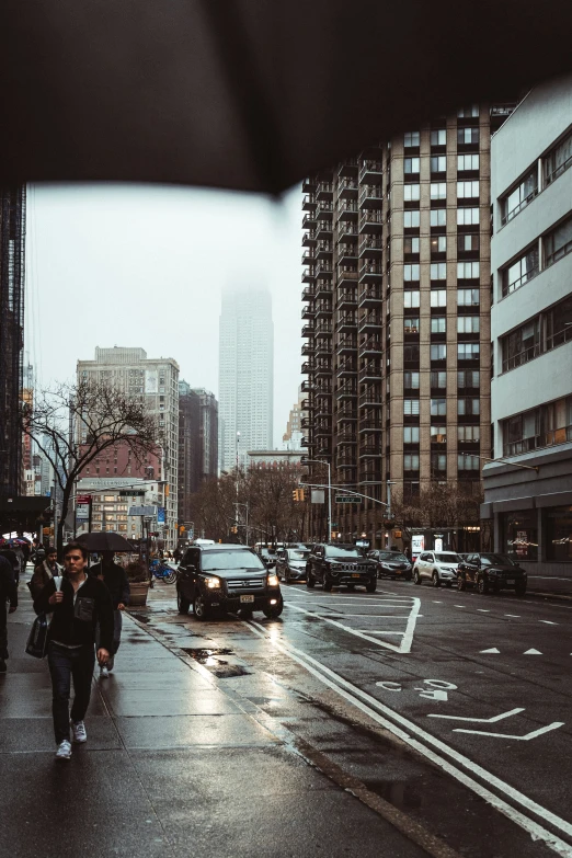 a city with very tall buildings and cars and people walking