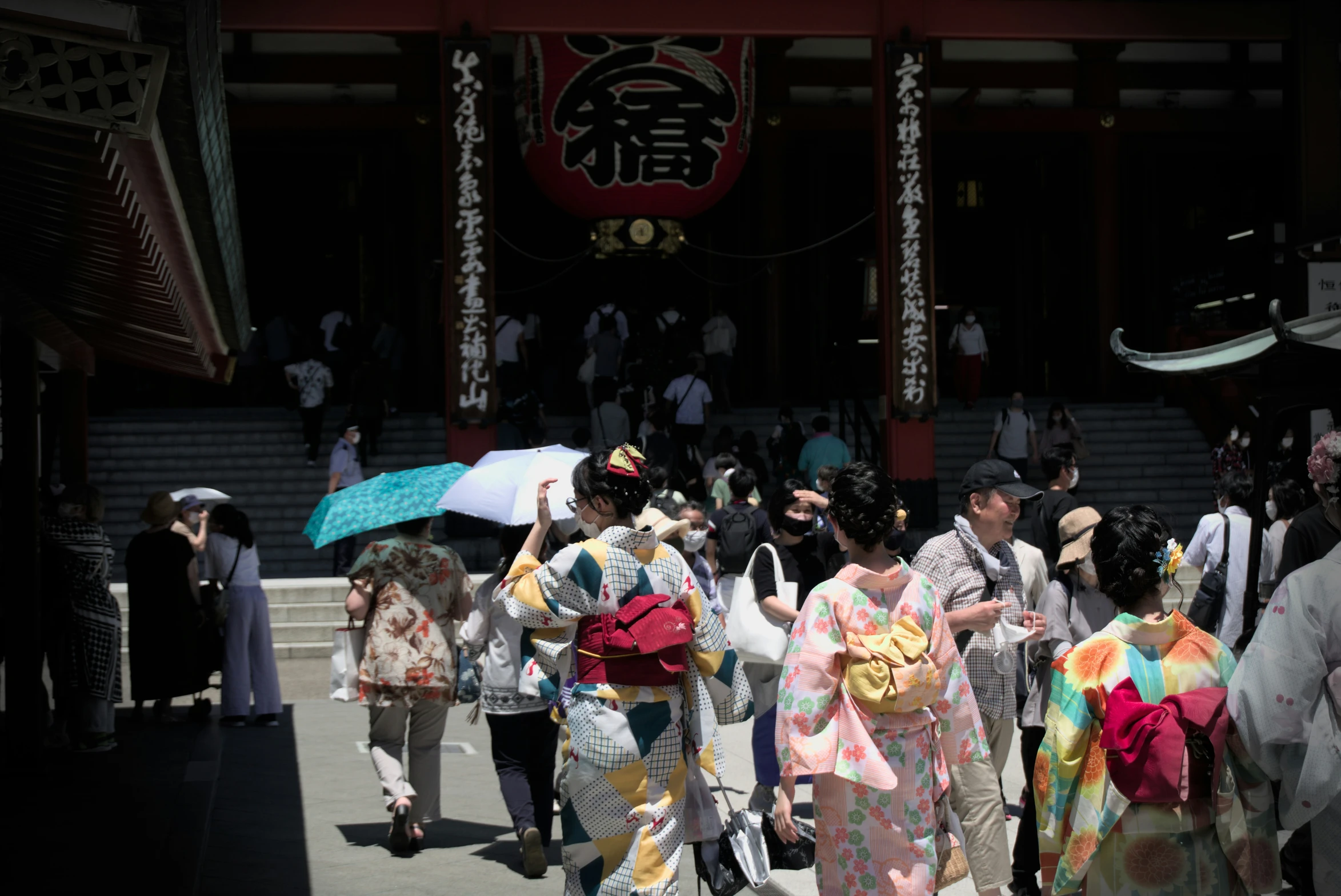 women in costumes carrying umbrellas walking on street