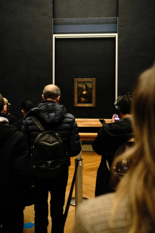 an older man and woman looking at a piece of art