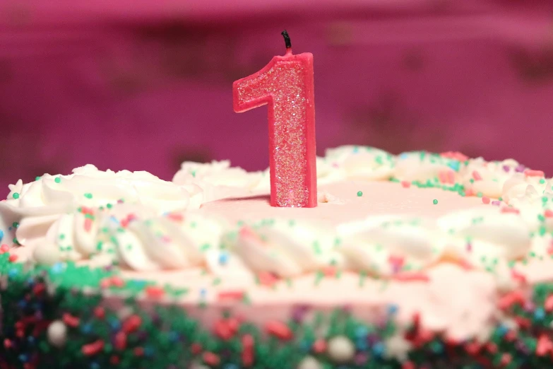 a cake with two red candles and some sprinkles