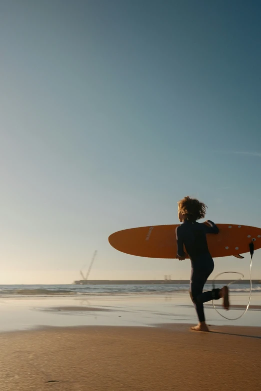 two people running into the water with their surfboards