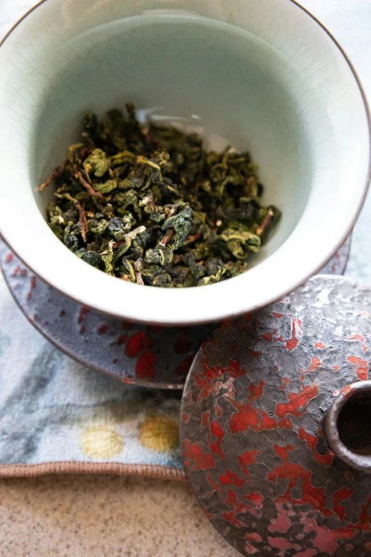 a small white bowl with some dry green items in it