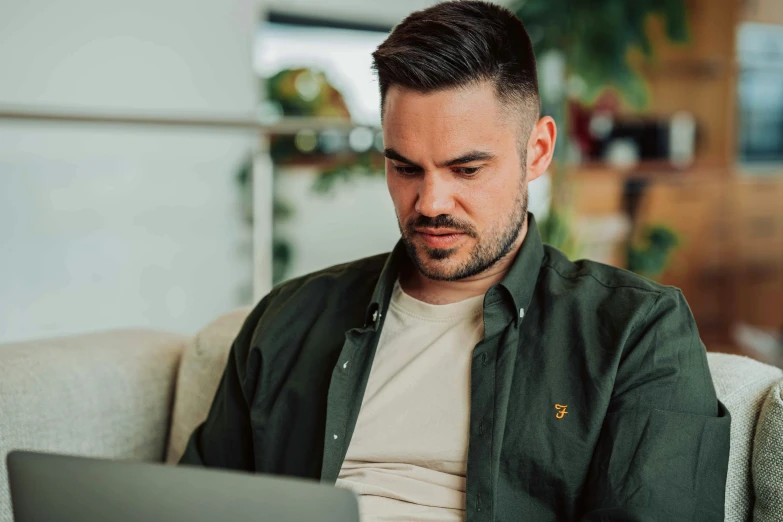 man using laptop on couch in large room