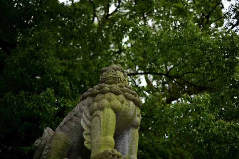 an elephant statue is in front of the trees