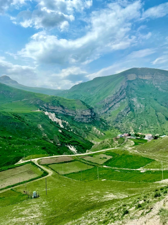 the view of a beautiful green valley with a winding road
