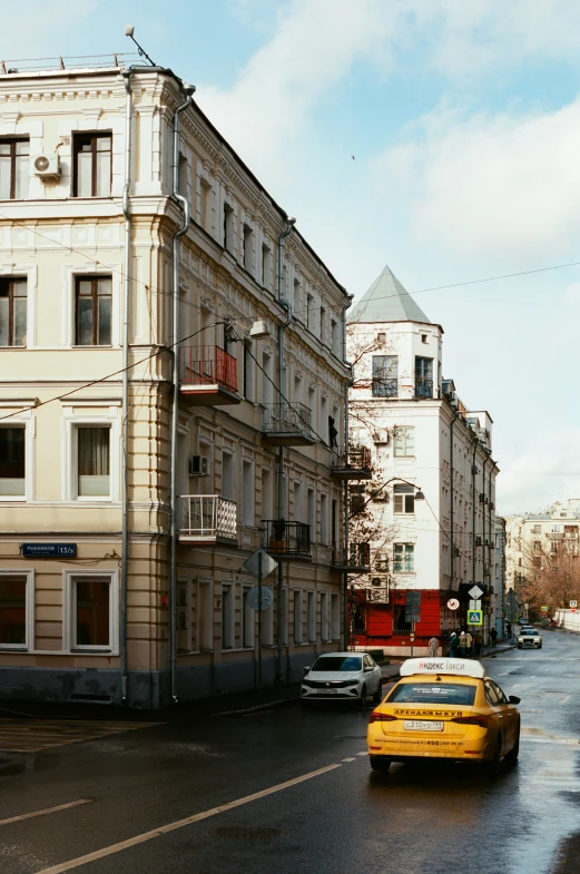 a yellow taxi cab driving on a city street