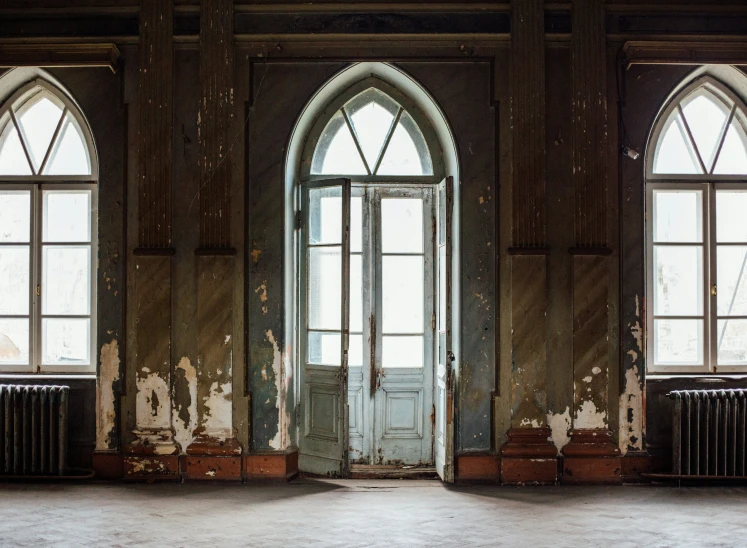 a door in an empty building with three windows