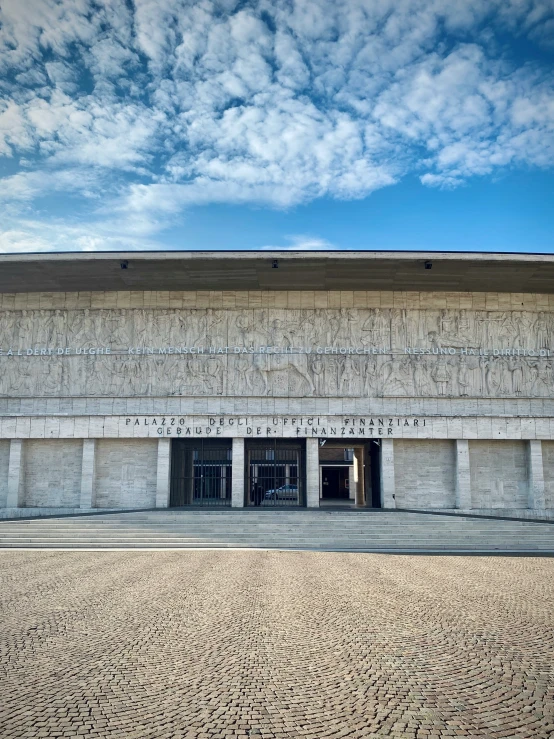 the side of an old, concrete building with a white and grey stripe