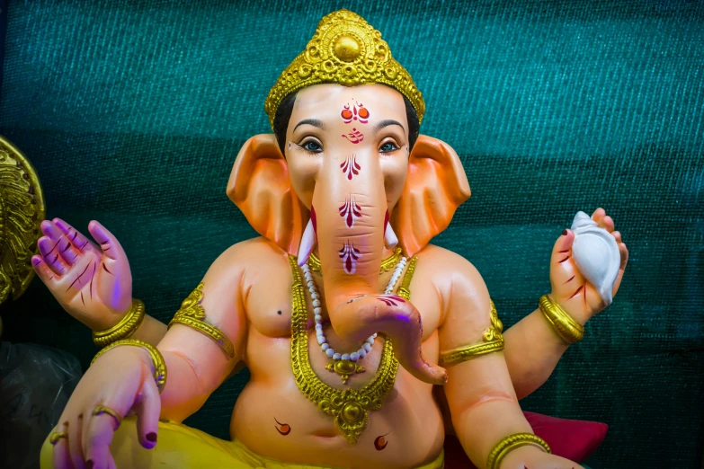 a figurine of an elephant with gold paint and a hat