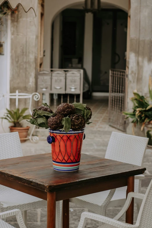 a table with an orange flower pot sitting on top of it