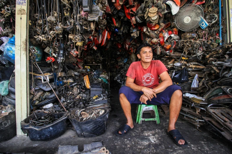 a man sits on a chair in front of a market