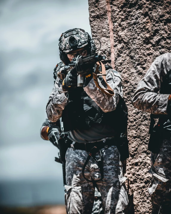 soldiers taking down a wall with a rifle