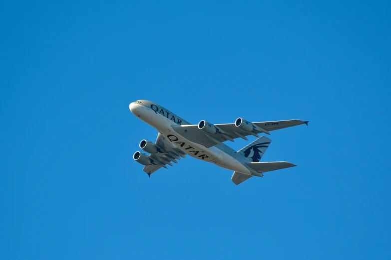a plane flies through the blue sky on a sunny day