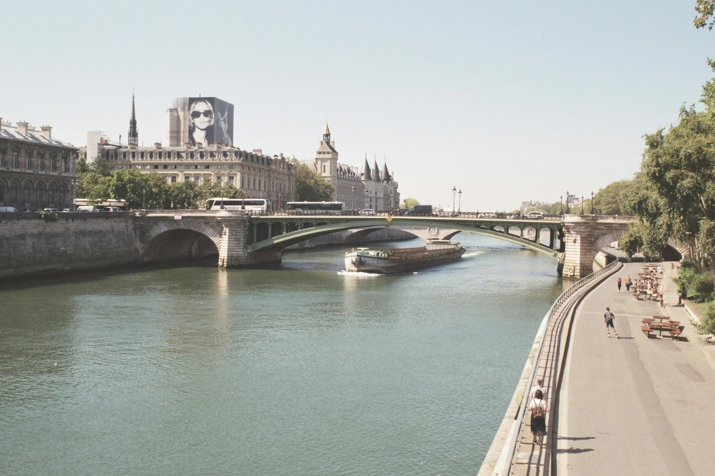 a bridge over water next to buildings and people