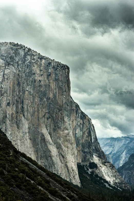 large rock mountain sitting on the side of a hill