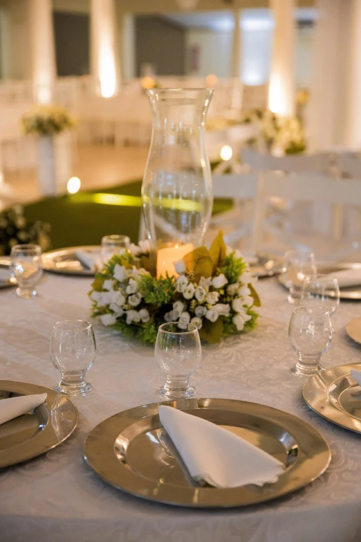 a table is set with silver plates and place settings