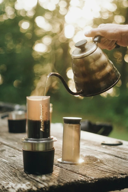 a person pouring coffee into a glass