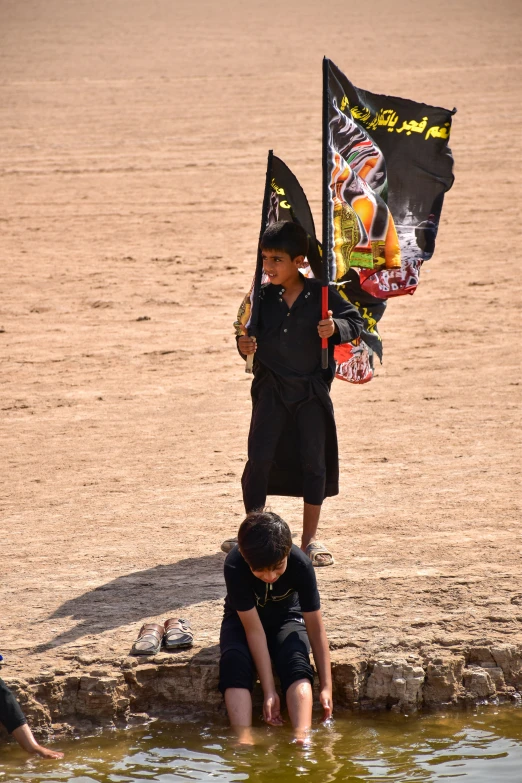 a boy and girl are on the ground with a kite