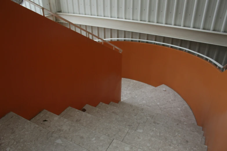 view down a spiral staircase way with a metal railing