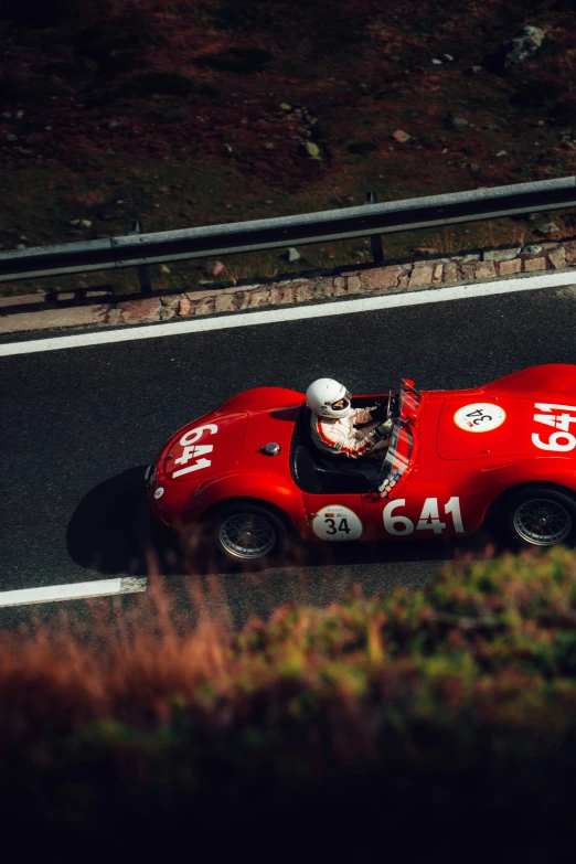 a man driving a race car down a road