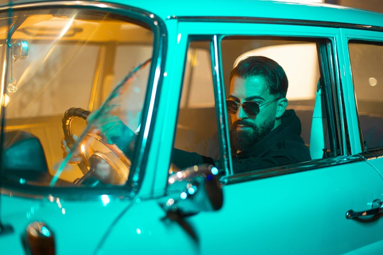 a man in sunglasses is sitting in the passenger seat of a car