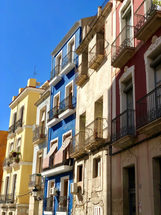 many different buildings and balconies are painted in colors