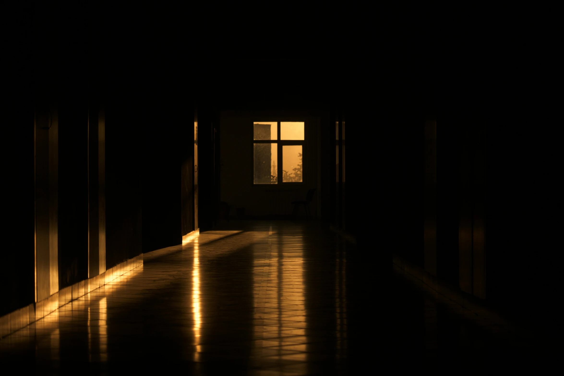 a hallway is lit by a sun through the window