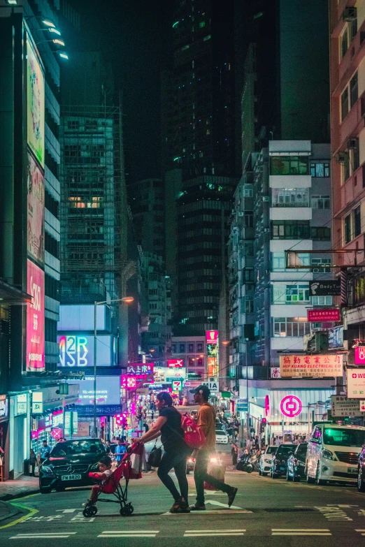 two men crossing the street at night, as cars pass by