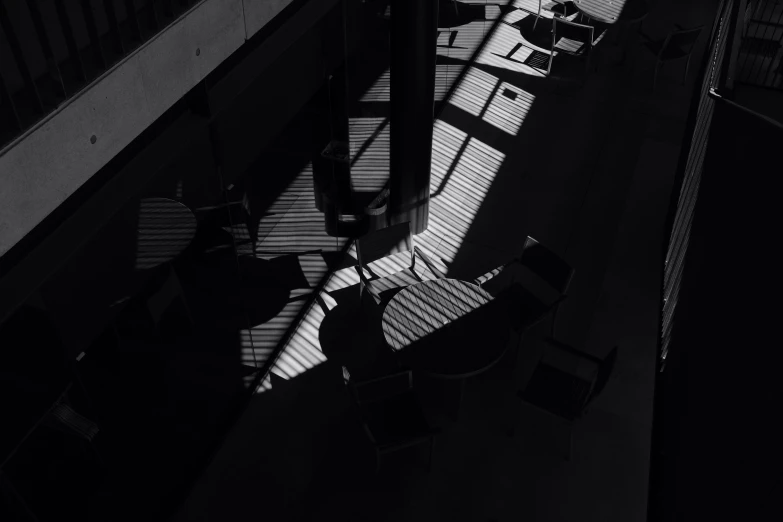 black and white po of chairs and tables with sunlight coming through them