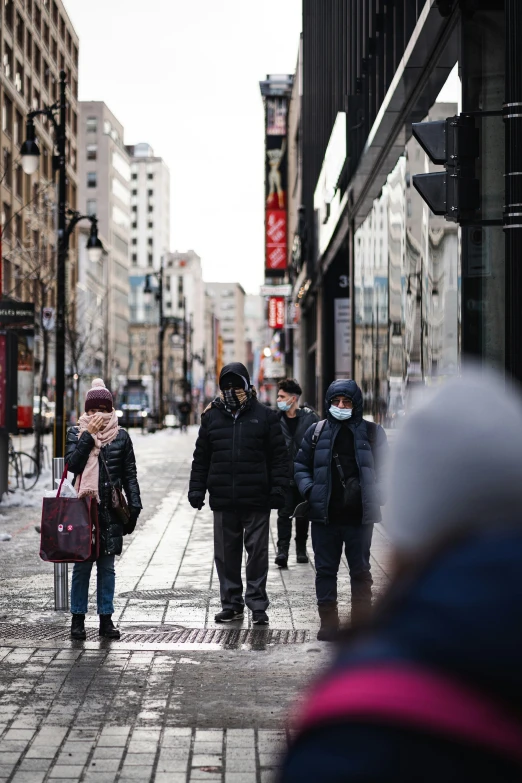 a group of people walking down the street in a city