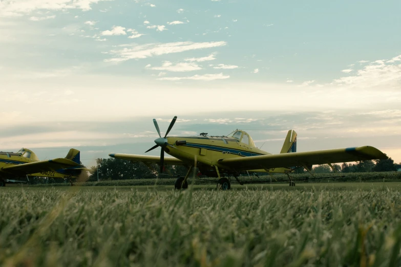 several propeller planes sitting on top of a field