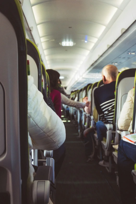 two people sit in seats on an airplane