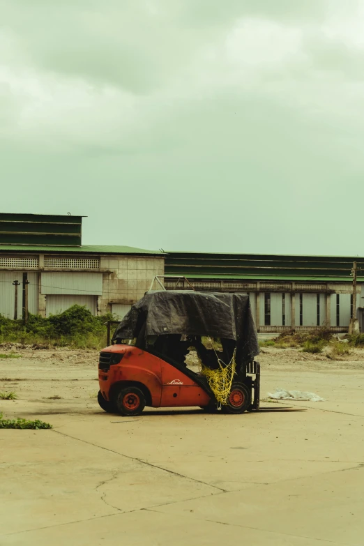 a black tarp covering an orange car