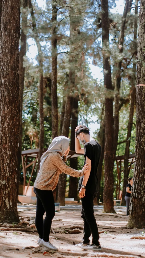 two people in the woods near some trees