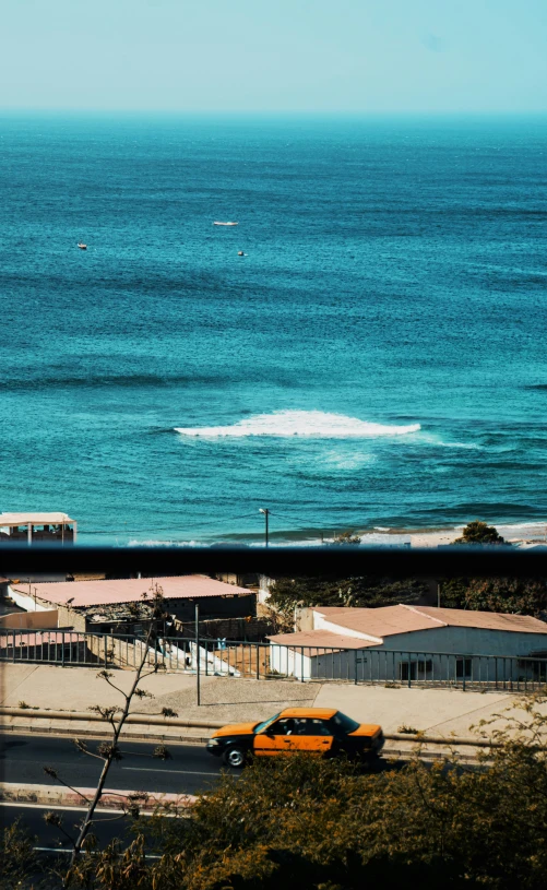 some yellow taxis are on the road near the ocean