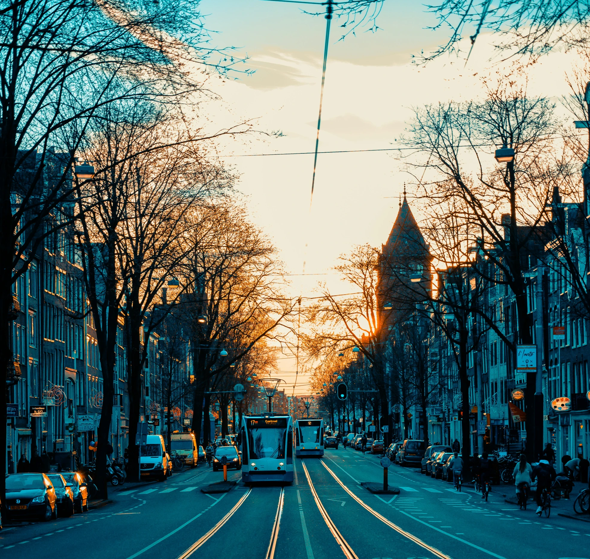 a street with a trolley going down it at sunset