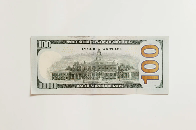 a ten dollar bill on a white surface