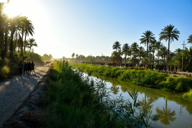 people on bicycles ride along a path beside a river