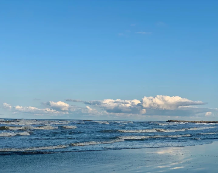 a lone boat is out on the water next to waves