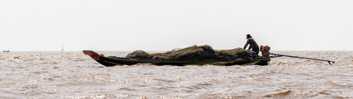 a small boat filled with rocks and people standing on top of it