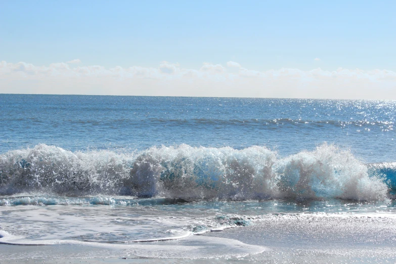 waves roll in on the beach as the sun rises