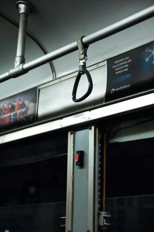 a gray wall with black doors and a handle on the inside of a bus