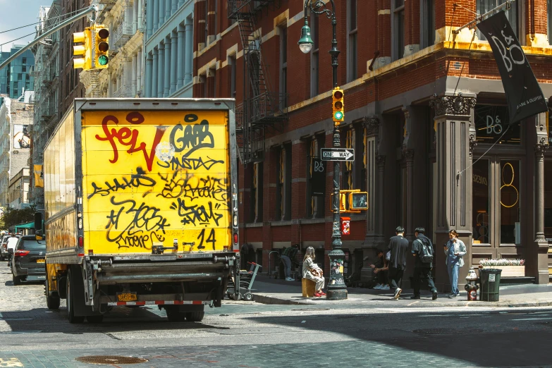 the yellow truck has graffiti on it's side