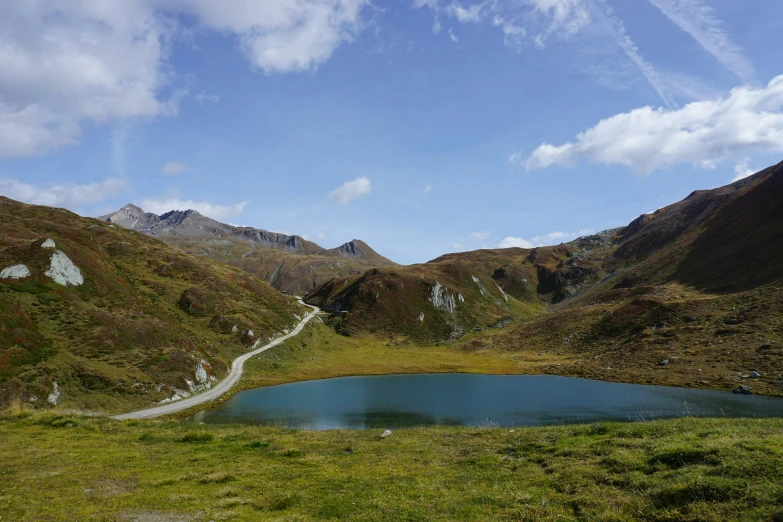 a beautiful blue lake in the middle of a grassy field