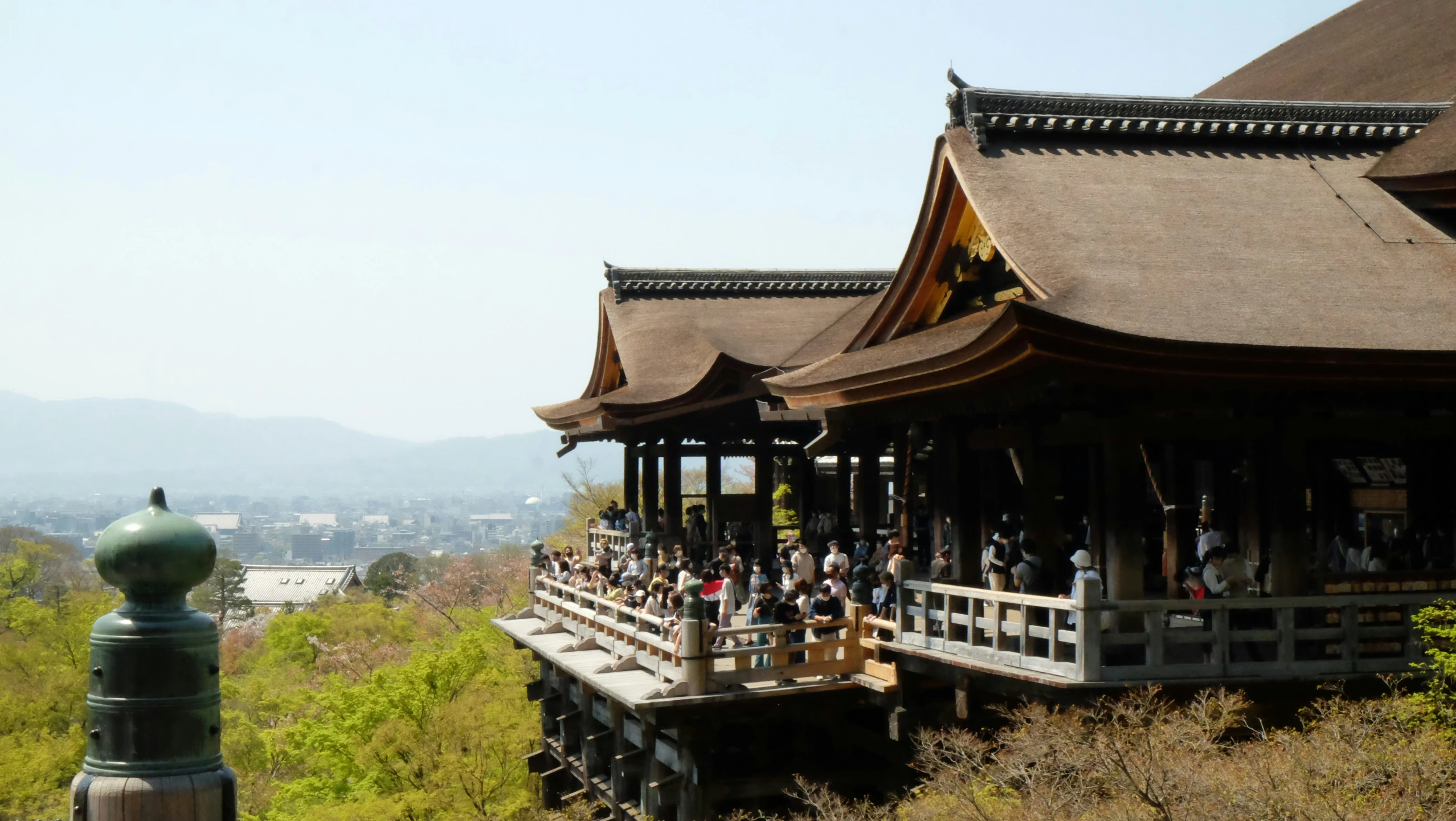 a chinese wooden pavilion with lots of people standing around